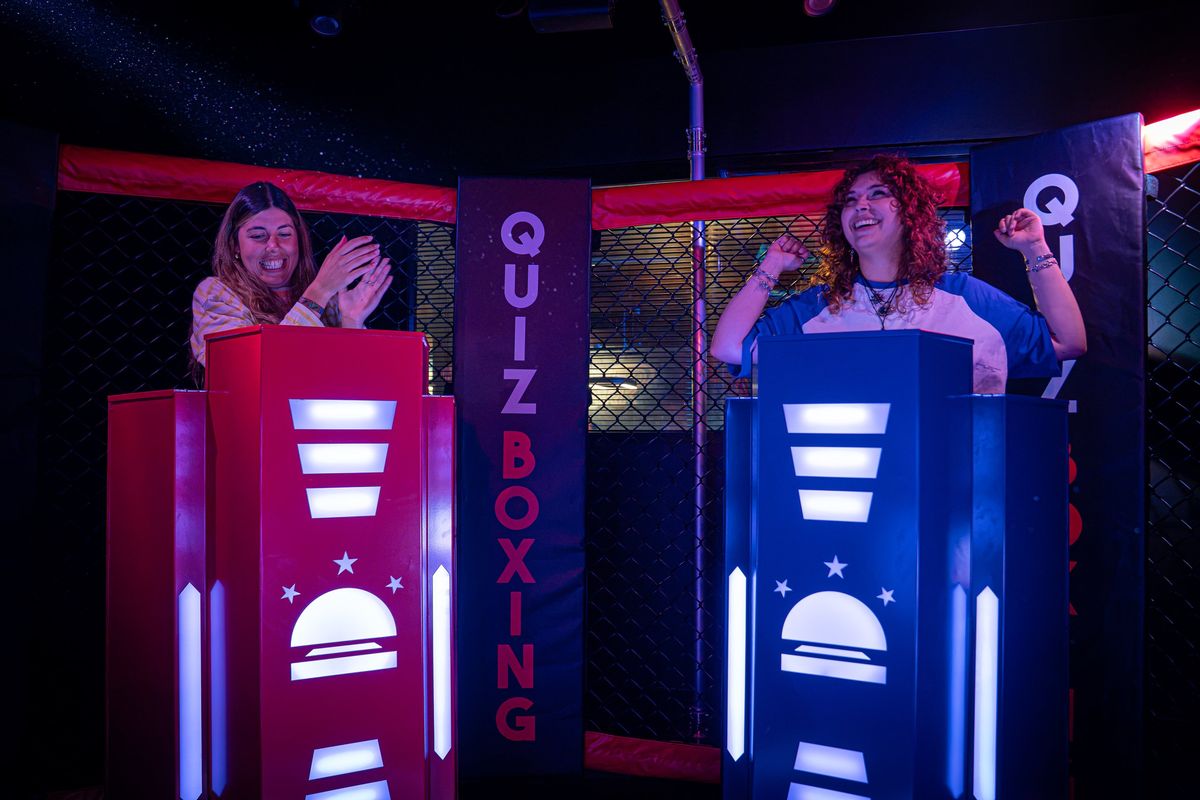 Deux joueuses s'affrontent à leurs pupitres sous la bannière Quiz Boxing, dans l'arène grillagée du Space Bowling Nîmes