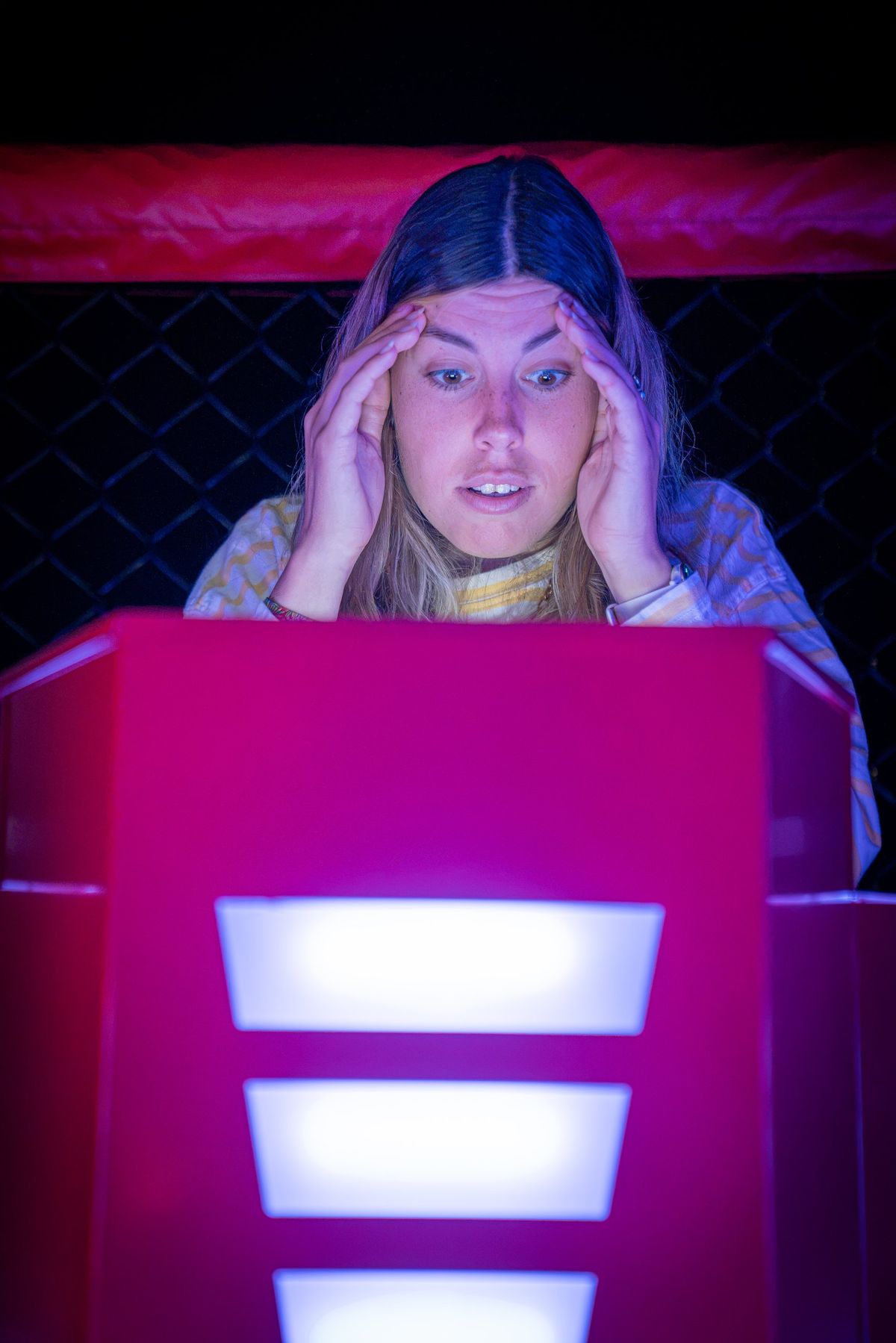 Joueuse surprise devant son pupitre lumineux pendant une manche de Quiz Boxing à Nîmes